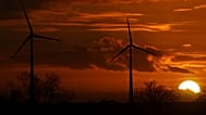 The sun sets behind wind turbines near Pokrent, northern Germany, Friday, Nov. 17, 2017.