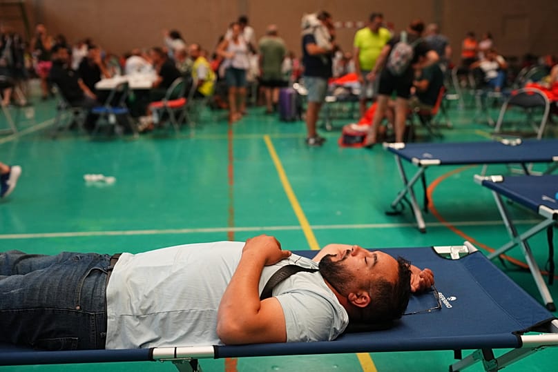 Los residentes pasan la noche en un polideportivo tras ser evacuados de sus hogares debido a la amenaza de un incendio forestal en Cebreros, provincia de Ávila, España.