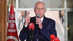 Tunisian President Kais Saied waves to citizens while delivering a speech during his visit to Sidi Bouzid, Tunisia.