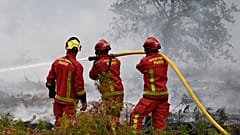 Des pompiers arrosent une forêt près de Marcheprime, dimanche 26 juillet 2026.