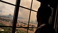 A resident looks as flames advance during a wildfire in Pumarejo de Tera in north western Spain