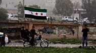 متظاهرون يرفعون العلم السوري خلال تجمع في درعا لإحياء الذكرى الـ15 للانتفاضة ضد نظام بشار الأسد، 18 مارس/آذار 2026.