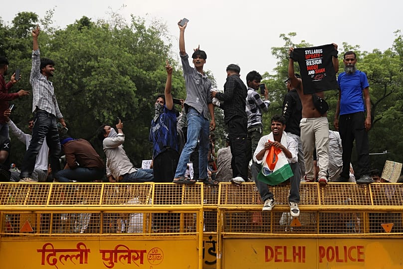 Protesters react after India's education minister Dharmendra Pradhan resigned following nationwide "Cockroach" demonstrations in New Delhi, India, Saturday, July 25, 2026. 