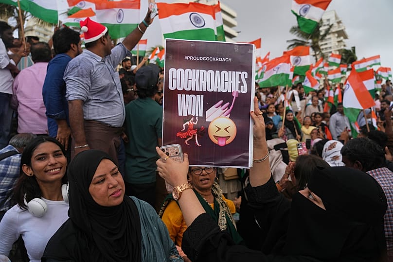 A protester holds a placard after India's Education Minister Dharmendra Pradhan resigned following nationwide protests in Mumbai, India, Saturday, July 25, 2026.