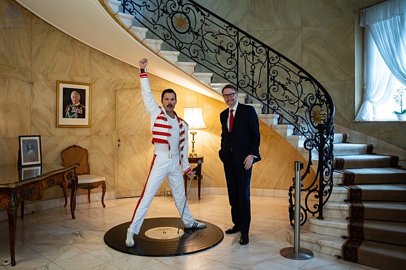 Justin McKenzie Smith brit nagykövet Freddie Mercury viaszszobra mellett áll a rezidencián