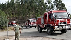 ARQUIVO (15.08.2017). Soldados do Exército Português observam um comboio de carros de bombeiros a percorrer uma estrada florestal perto de Vila de Rei.