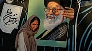 امرأة تسير أمام جدارية تحمل صورة المرشد الأعلى الإيراني علي خامنئي وسط العاصمة الإيرانية طهران، يوم السبت 18 يوليو 2026.
