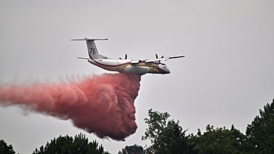A francia polgári védelem De Havilland Canada DHC-8-400 Dash 8 gépe tűzgátló anyagot szór, miközben erdőtüzek tombolnak Marcheprime közelében, Bordeaux mellett, július 27-én.