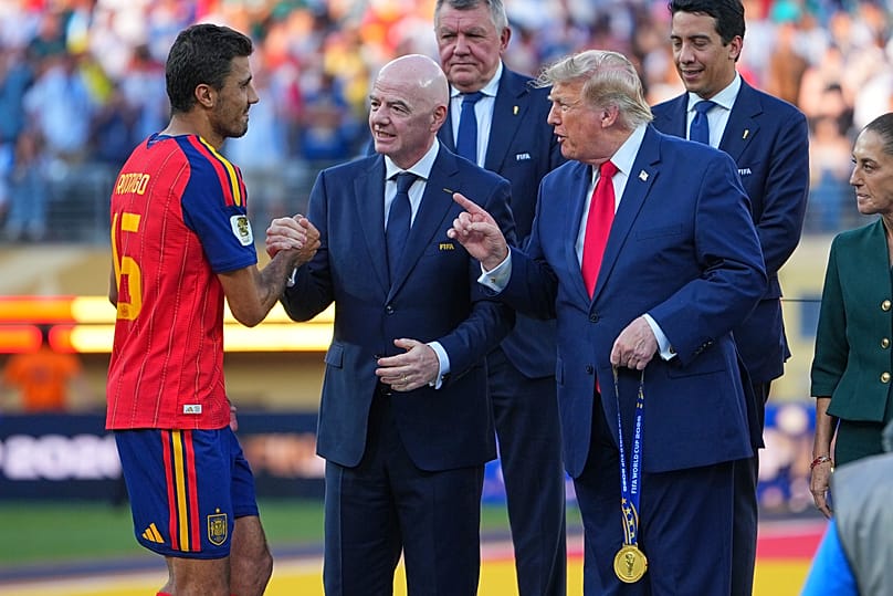 Spain's Rodri (16) is greeted by FIFA President Gianni Infantino and President Donald J. Trump during the presentation ceremony after the World Cup final.