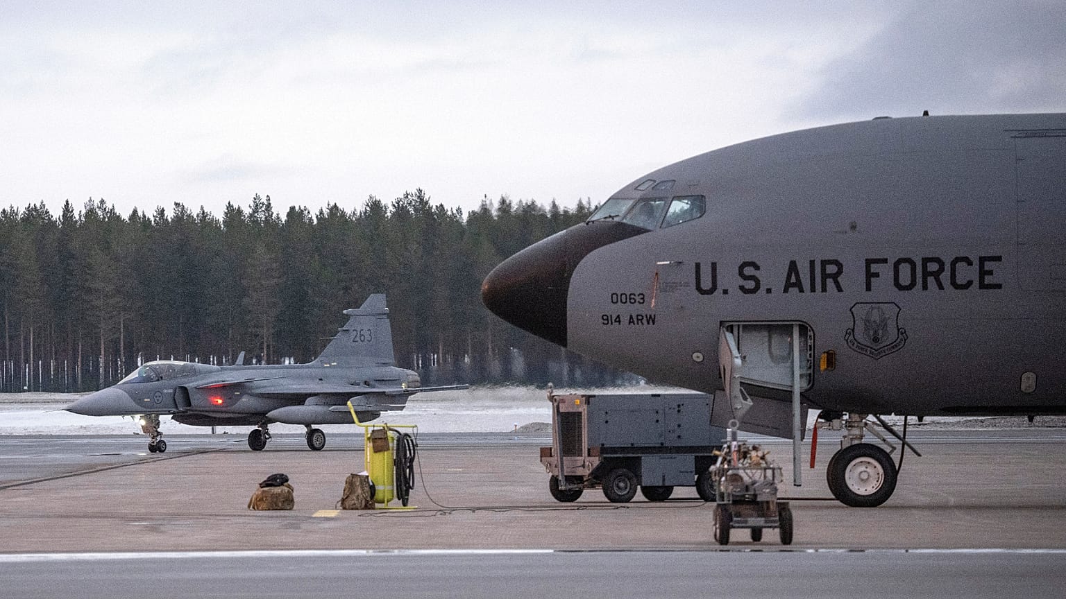 A fighter jet, left, passes a US KC-135 Stratotanker, a US military tanker aircraft, during a military exercise near  Luleå, Sweden, March 4, 2024