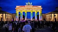 Pessoas juntam-se diante do Portão de Brandemburgo, iluminado com a mensagem “Berlim, cidade da liberdade”, em homenagem às vítimas após um carro atingir a multidão na Pride