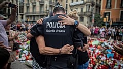 Arquivo: Um polícia abraça uma criança e a família, a quem ajudou durante o atentado terrorista, em Las Ramblas (Barcelona), Espanha.