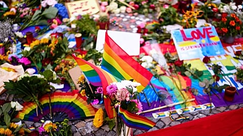 Flowers and rainbow flags placed in front of the Brandenburg Gate commemorating the victims of a car attack on Saturday's Pride March in Berlin, Germany, Monday, July 27, 2026