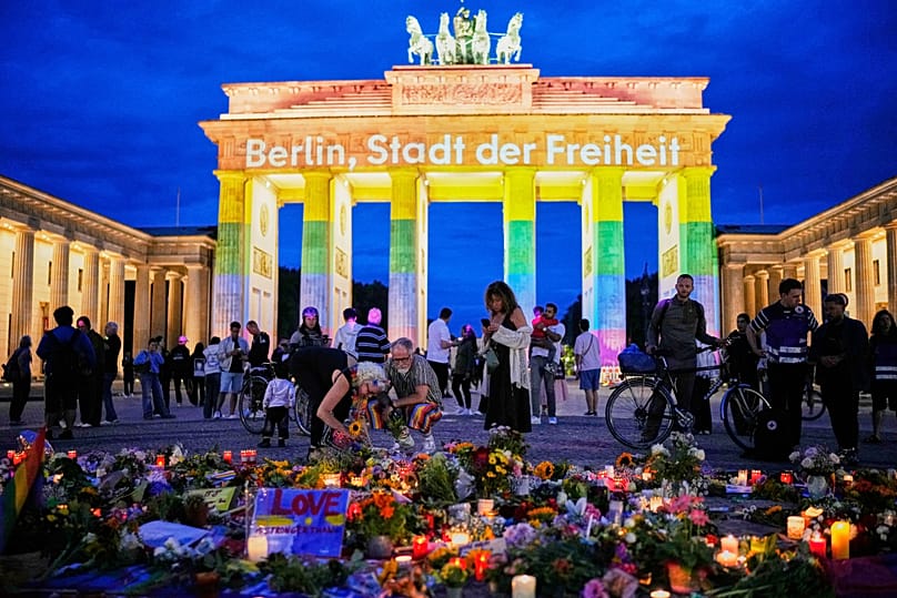 People gather in front of the Brandenburg Gate commemorating the victims, after a car rammed into a crowd at the Pride March in Berlin, Sunday, July 26, 2026.