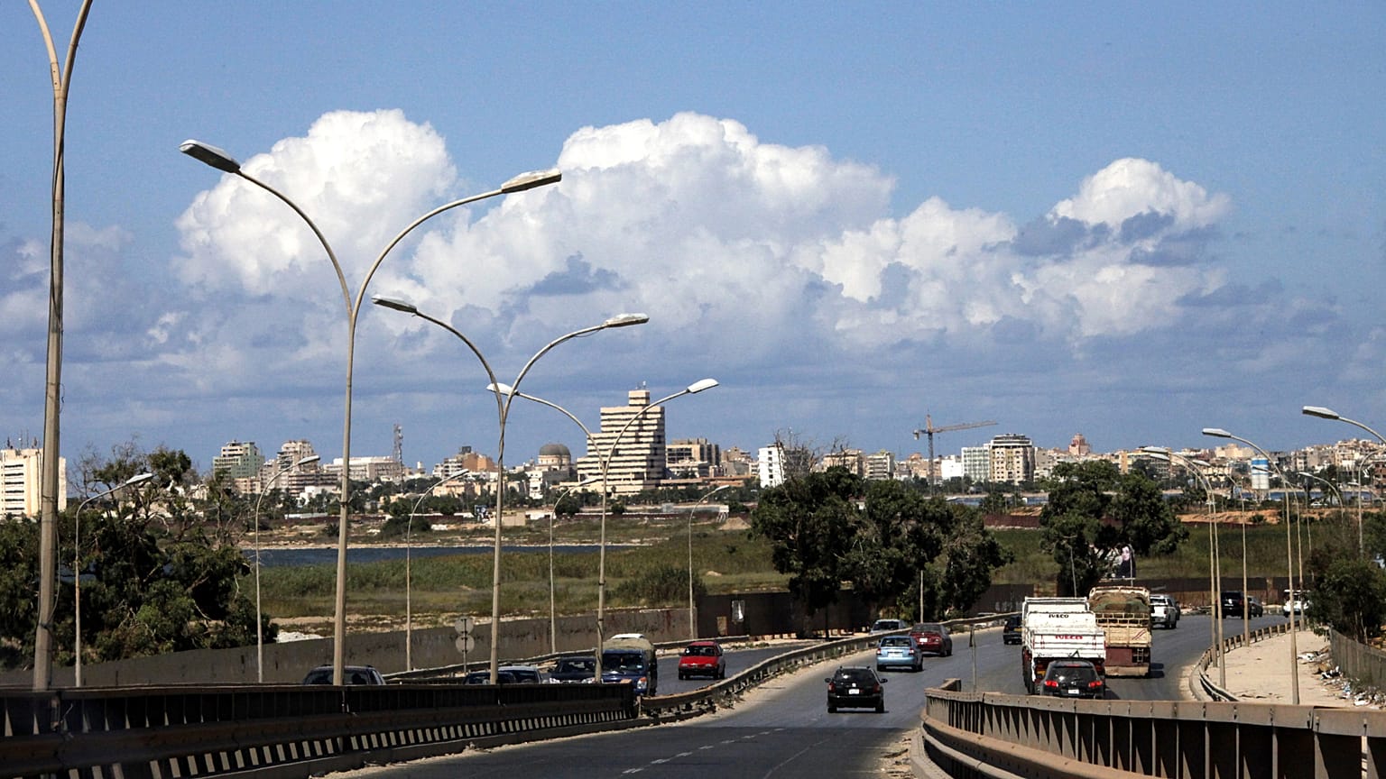 في هذه الصورة الملتقطة يوم الاثنين 17 سبتمبر/أيلول 2012، يظهر مشهد عام لمدينة بنغازي الليبية. أمام سوق بنغازي للأوراق المالية، يتجنب المارة برك مياه الصرف الصحي في الشارع. (صو