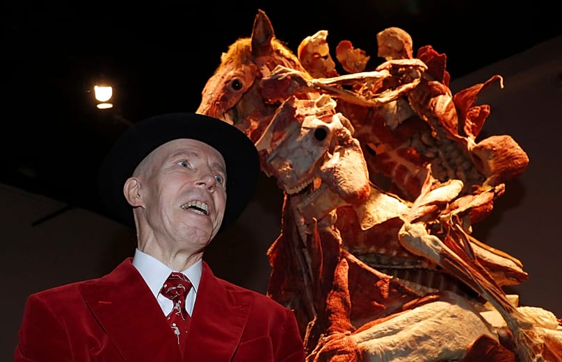 Gunther von Hagen poses in front of the sculpture 'Rearing Horse with Rider' during the launch of Gunther von Hagens' Body Worlds museum in London, Thursday, 4 Oct., 2018.