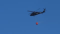 Un helicóptero transporta agua para combatir un incendio cerca de las localidades de Psevdas y Kalo Chorio, en el distrito de Lárnaca, en Chipre.