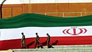 FILE: Iranian police units walk next to the Islamic Republic's national flag at the Azadi Stadium in Tehran, 3 June 2005