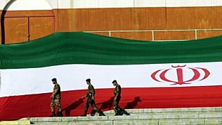 FILE: Iranian police units walk next to the Islamic Republic's national flag at the Azadi Stadium in Tehran, 3 June 2005