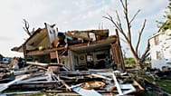 Обломки видны перед повреждённым домом после торнадо, прошедшего в понедельник, 27 июля 2026 года, в Менаше, Висконсин.
