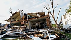 Se ven escombros frente a una casa dañada tras el paso de un tornado el lunes 27 de julio de 2026 en Menasha, Wisconsin.
