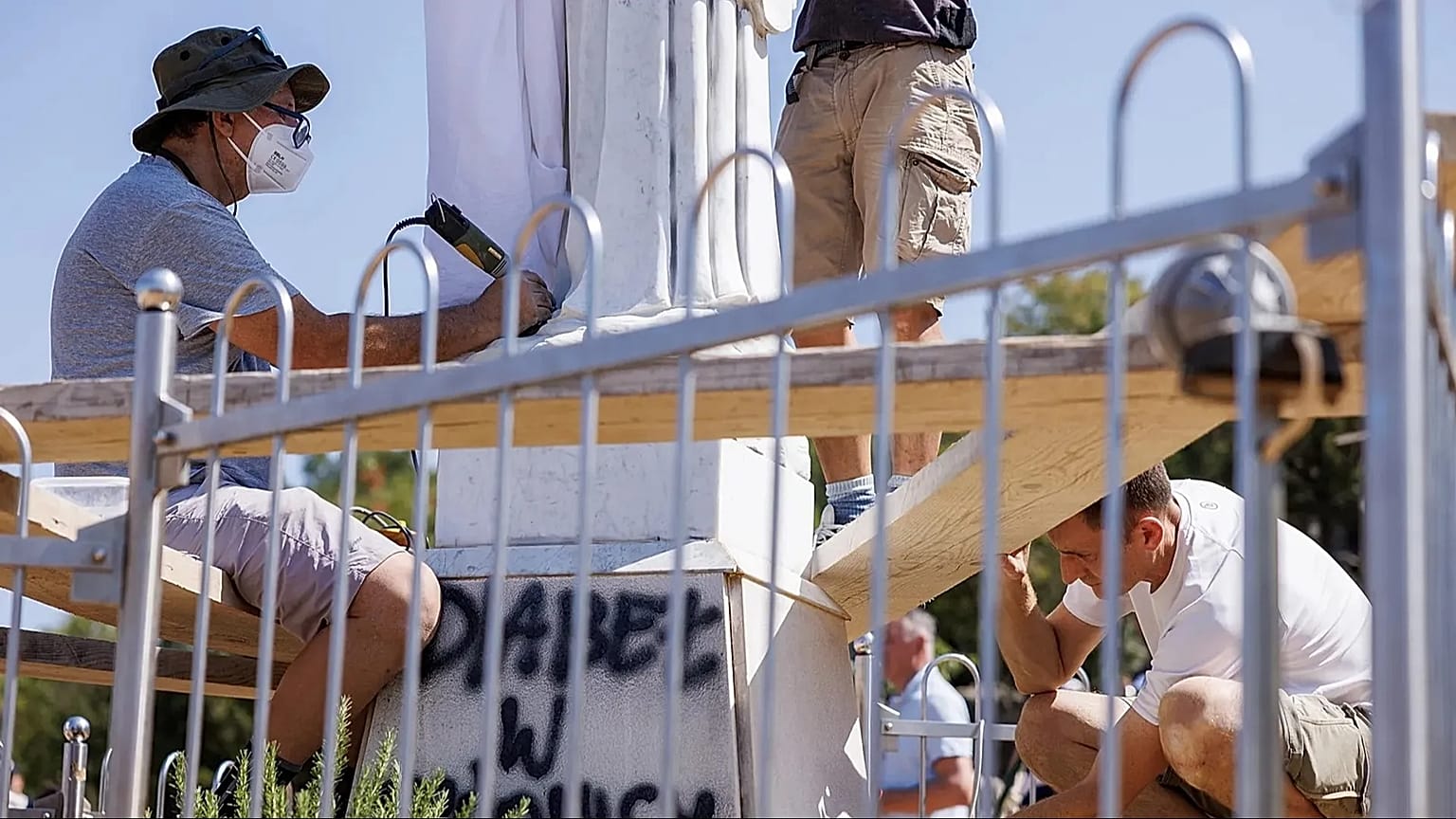 Volontari che puliscono la statua della Vergine vandalizzata, sulla collina delle apparizioni, a Medjugorje