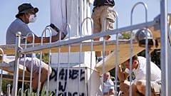 Dos voluntarios limpian la estatua de la Virgen vandalizada en la colina de las apariciones, en Medjugorje