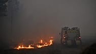 Un camion dei vigili del fuoco nel fumo di un incendio boschivo che devasta la zona di Marcheprime, alla periferia di Bordeaux, in Francia, 26 luglio 2026