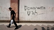 A man walks past anti-US graffiti on the wall of the British Embassy in Tehran, Iran, Monday, July 27, 2026