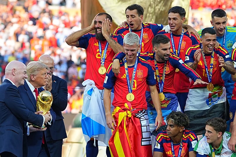 FIFA President Gianni Infantino and President Trump carry the trophy to the Spanish team after the World Cup final in East Rutherford, New Jersey, Sunday, July 19, 2026