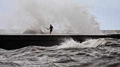 Unos niños juegan junto a las olas en el muelle West End mientras la tormenta tropical Bertha se aproxima a Luisiana, miércoles 22 de julio, en Nueva Orleans.