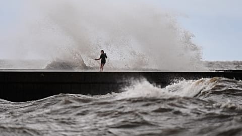Unos niños juegan junto a las olas en el muelle West End mientras la tormenta tropical Bertha se aproxima a Luisiana, miércoles 22 de julio, en Nueva Orleans.