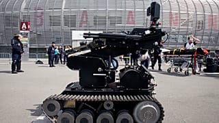 FILE - Police officers using a robot conduct a security exercise at the Pierre Mauroy Stadium, Villeneuve d'Ascq, northern France, Thursday April 21, 2016.
