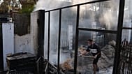 Moha Haddad intenta apagar un incendio en su casa mientras un incendio forestal continúa propagándose cerca de Navas del Rey, provincia de Ávila, España, 28 de julio de 2026