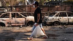 Un hombre lleva sus pertenencias mientras un incendio forestal sigue avanzando cerca de Navas del Rey, provincia de Ávila, España, martes, 28 de julio de 2026