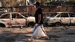 Un hombre transporta sus pertenencias mientras un incendio forestal sigue extendiéndose cerca de Navas del Rey, provincia de Ávila, España, el martes 28 de julio de 2026