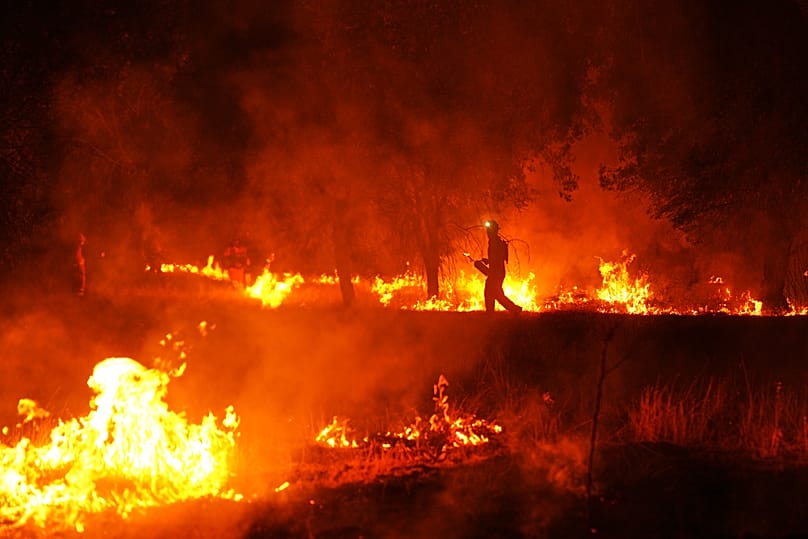 Firefighters use controlled burning to halt a wildfire that continues to spread near Cebreros, Ávila province, Spain, Tuesday, July 28, 2026.