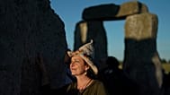 FILE: A reveler gathers at the ancient stone circle Stonehenge in England to celebrate the Summer Solstice, the longest day of the year, near Salisbury, June 21, 2026