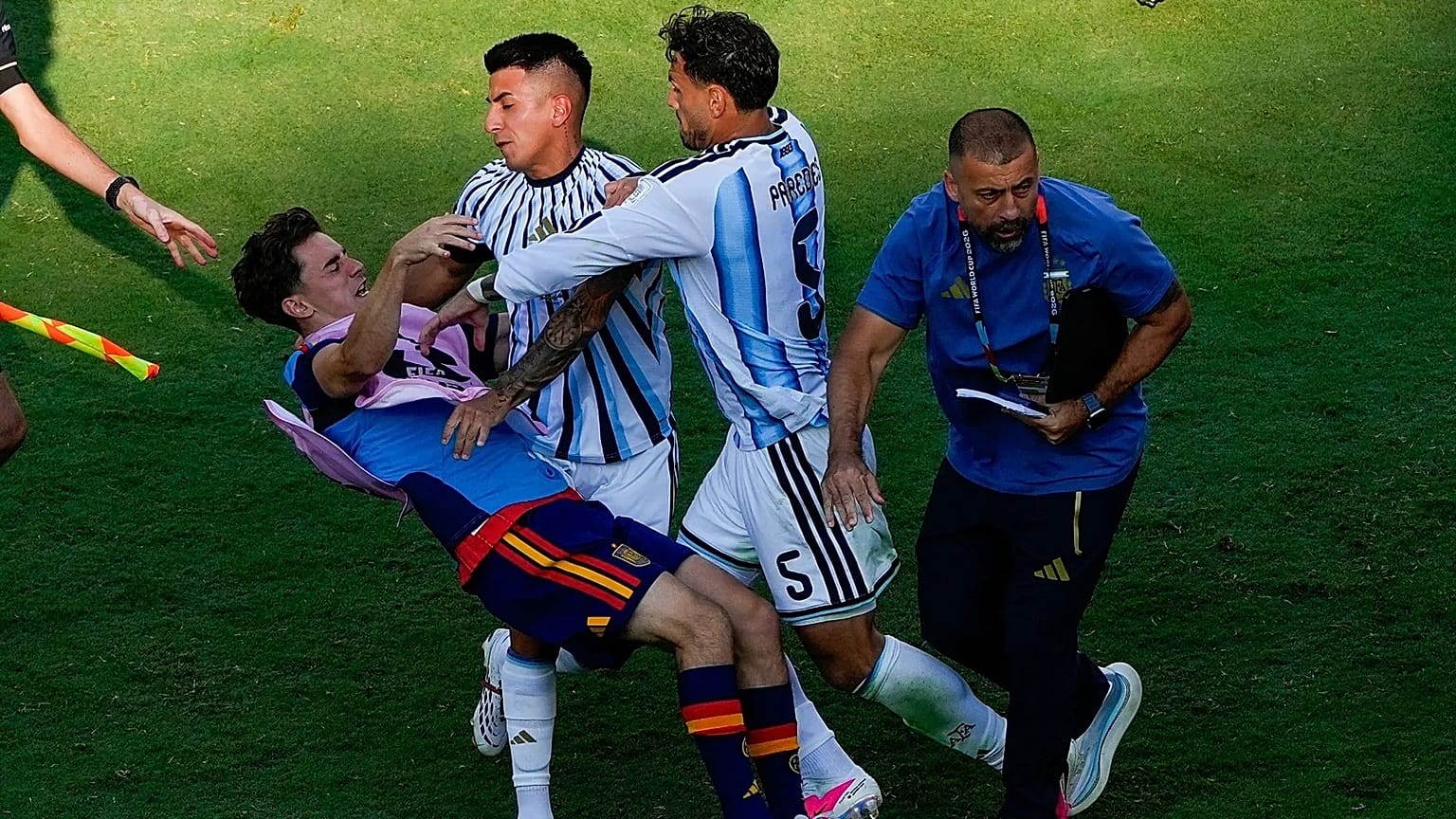 El español Gavi, a la izquierda, cae al suelo mientras se enzarza en un forcejeo con el argentino Leandro Paredes (5) y Thiago Almada durante la final del Mundial de fútbol en