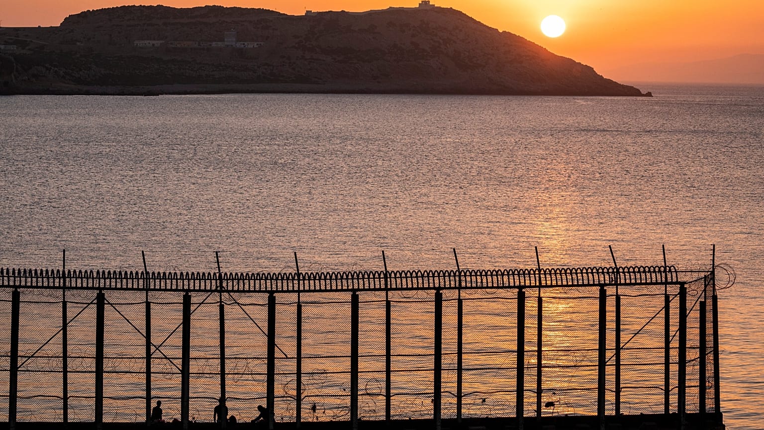 Moroccan men fish on the Moroccan side of the border with Spain, as seen from the district of Benzu in the Spanish enclave of Ceuta, 3 June, 2021.