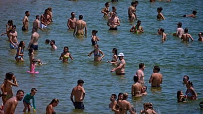 Badegäste kühlen sich im Wasser eines Strandes in Barcelona ab. Es ist ein heißer Samstag, der 28. Juni 2025.