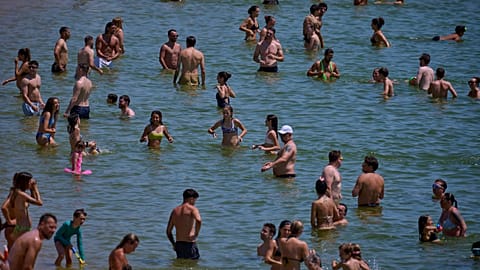 Swimmers cool off in the water at a beach on a hot day in Barcelona, Spain, on Saturday 28 June 2025.