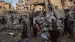 فلسطينيون ينقذون ممتلكاتهم من تحت أنقاض مبنى وخيام دمرت في غارة جوية إسرائيلية على مدينة غزة، الخميس 30 يوليو 2026. (AP Photo/جهاد الشرافي)