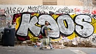 FILE: A man walks past graffiti in a dirty street of Rome's St. Lorenzo's neighbourhood, Friday, Sept. 17, 2021.