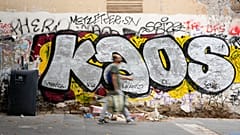 FILE: Un hombre pasa junto a unas pintadas en una calle sucia del barrio de San Lorenzo, en Roma, el viernes 17 de septiembre de 2021.