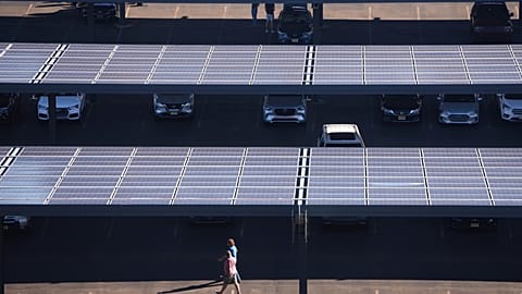 Pessoas caminham por um parque de estacionamento com painéis solares perto do Lincoln Financial Field, a 8 de setembro de 2025, em Filadélfia.