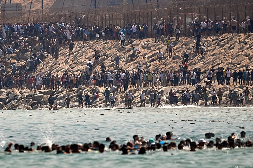 Migrantes atravessam a fronteira de Marrocos para o enclave espanhol de Ceuta, na quinta-feira, 30 de julho de 2026.