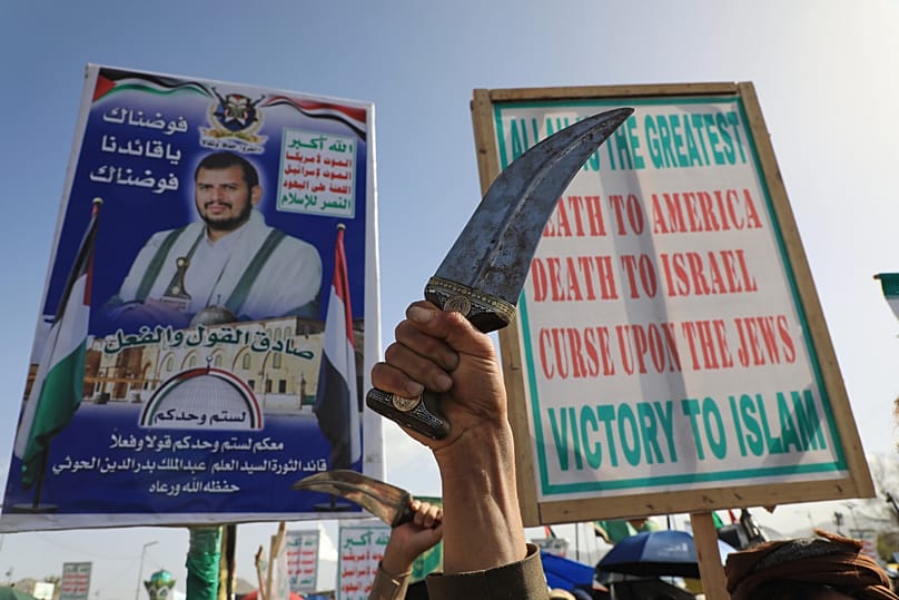 أنصار الحوثيين يرفعون لافتة تحمل صورة زعيم الحركة عبد الملك الحوثي خلال تجمع في صنعاء احتجاجاً على الحرب الأمريكية والإسرائيلية على إيران.