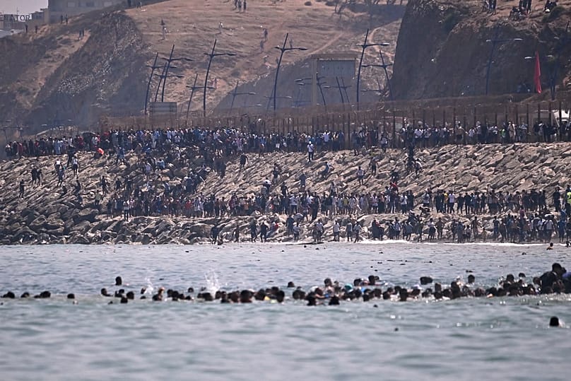 Migrants cross from Morocco into the Spanish enclave of Ceuta, Thursday, July 30, 2026.