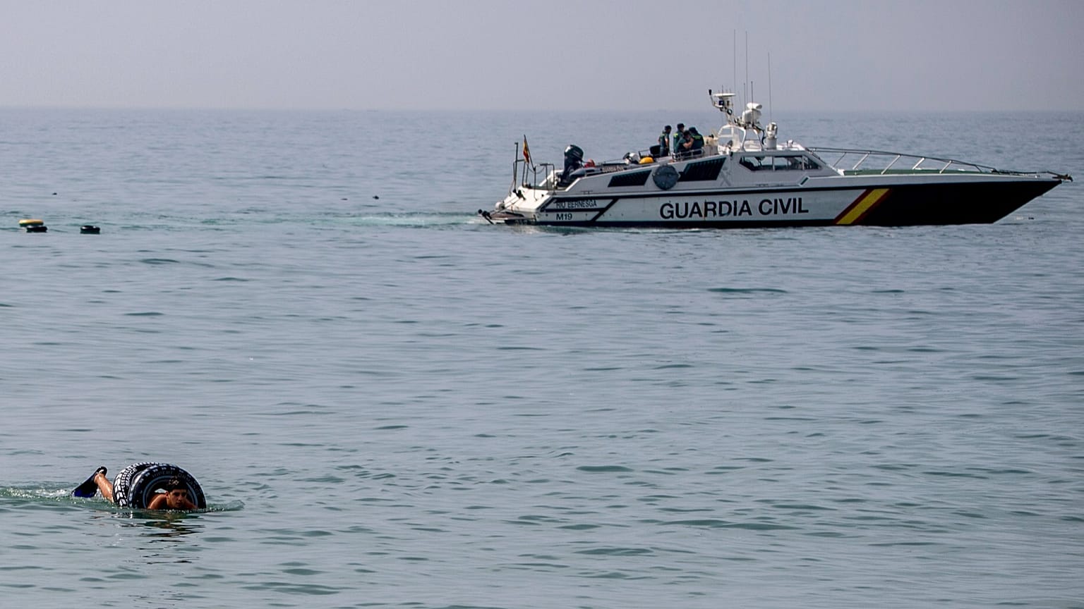 Un migrante utiliza un flotador mientras intenta cruzar a Ceuta desde Marruecos, el 30 de julio de 2026.